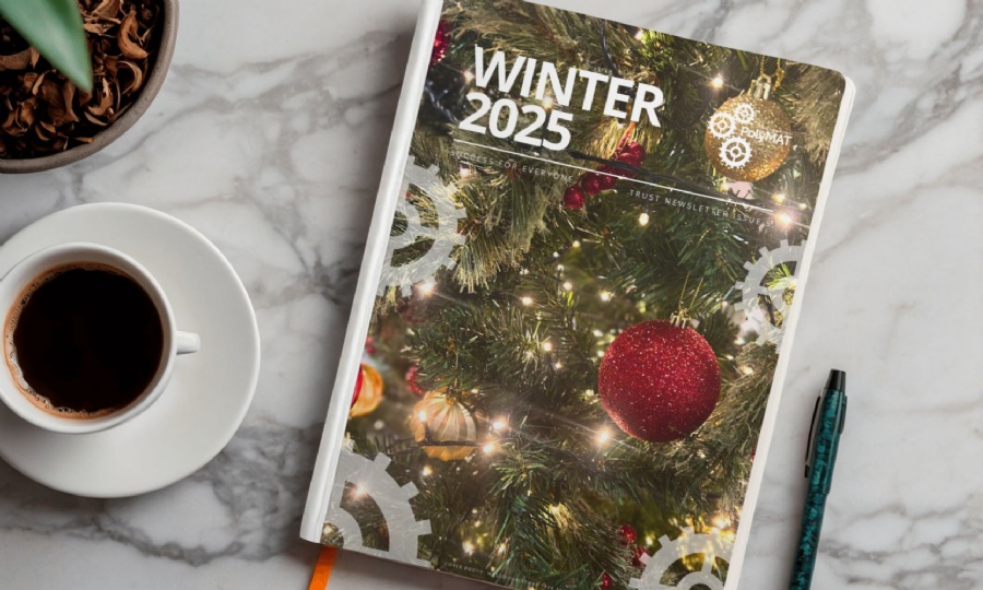 Winter Newsletter on a table with a cup of coffee